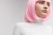 Female robot in pink wig looking away