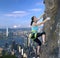 Female rock climber over the city skyline