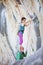 Female rock climber standing on shoulders of her partner in order to start climbing challenging route