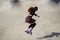 Female roller blader jumping in a skate pool outdoor. Young adult skater in aggressive inline skates riding in a concrete bowl in