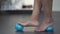 Female rolling feet on massaging ball, stretching bottom of foot, pain release