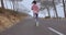Female runner athlete running on country road