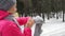 Female runner jogging in cold winter forest wearing warm sporty running clothing and gloves.