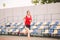 Female runner jogging on stadium track, woman athlete running and working out outdoors, sport and fitness concept. Young woman in