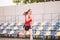 Female runner jogging on stadium track, woman athlete running and working out outdoors, sport and fitness concept. Young woman in