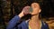 Female runner in the park. Woman drinks water standing in the autumn park covered with fallen leaves