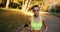 Female runner in the park. Woman looks straight in the camera while she runs along the path in the autumn park covered