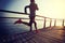 Female runner running on seaside boardwalk