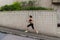 Female runner running uphill on town street. Sporty young woman doing cardio exercises outdoors.