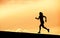 Female runner silhouette, running into sunset