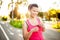 Female runner smiling at camera while running in city park