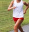 Female runner in white and red uniform racing