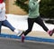 Female runners performing running drills in a high school parking lot due to snow