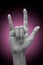 Female`s hand doing sign language `I love you`. isolated on gradient background.  Metal sign. Communication concept