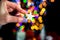 Female\'s hand holding a Christmas glittery star decoration near a wall with blurred lights