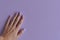 Female\'s hand with nails of purple color