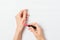 Female\'s hands applying test sample of pink lipstick