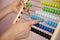 Female`s hands count on multi-colored abacus