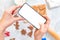 Female`s hands takes a photo of ginger cookies on a smartphone. Flat lay. Mock up. The background is blurred. The concept of