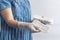 Female`s hygiene products. Woman in medical gloves holding a stack of sanitary napkins against white background. Period days