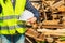 Female with safety helmet near pile of boards