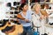 Female sales consultant helps a mature woman to choose winter shoes