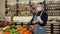 A female saleswoman wearing a medical mask puts on gloves at a grocery store.