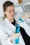 Female scientific researcher looking at tube in laboratory