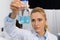 Female Scientist Examine Flask With Blue Luquid Working In Modern Laboratory, Attractive Woman Researcher Making