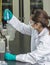 Female scientist experimenting chemicals test glass