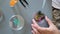 Female scientist hands shaking petri dish with glitters mix sample and analysis liquid in lab