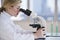 Female scientist looking through microscope