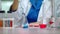 Female scientist pouring reagent in lab flask. Scientist doing chemical reaction