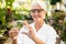 Female scientist smiling while examining leaf on petri dish