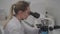 Female scientist using microscope while working in laboratory. Lab for modern medical research. Woman laboratory