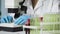 Female scientist viewing bacteria sample on microscope, biochemical research