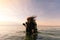 Female Scuba Dive Instructor Wearing a Dry Suit, a Twin Tank and Holding Fins Flipping Wet Hair in the Air