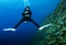 Female scuba diver swimms backwards