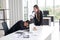 Female secretary holds a megaphone to wake the boss who is tired