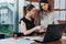 Female secretary looking concerned while her boss checking document sitting at desk in modern office