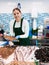 Female seller in apron standing near counter offering fresh fish flounder