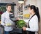 Female seller assisting customer in grocery shop