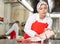 Female seller demonstrating meat in butcher shop