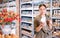 Female shopper choosing pottery glaze jars in pottery specialty store