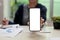 Female showing cellphone screen over her offie desk