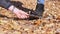 Female Shows a Torn Shoe, Standing on the Lush Fallen Leaves in the Autumn Wood