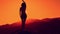 Female silhouette dancing at beautiful sunset on mountain background