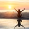 Female silhouette doing yoga exercise at beautiful sunset on the sea beach