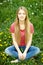 Female sitting on the field of dandelions