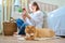 Female sitting on floor using smartphone, pet cat lying near owner